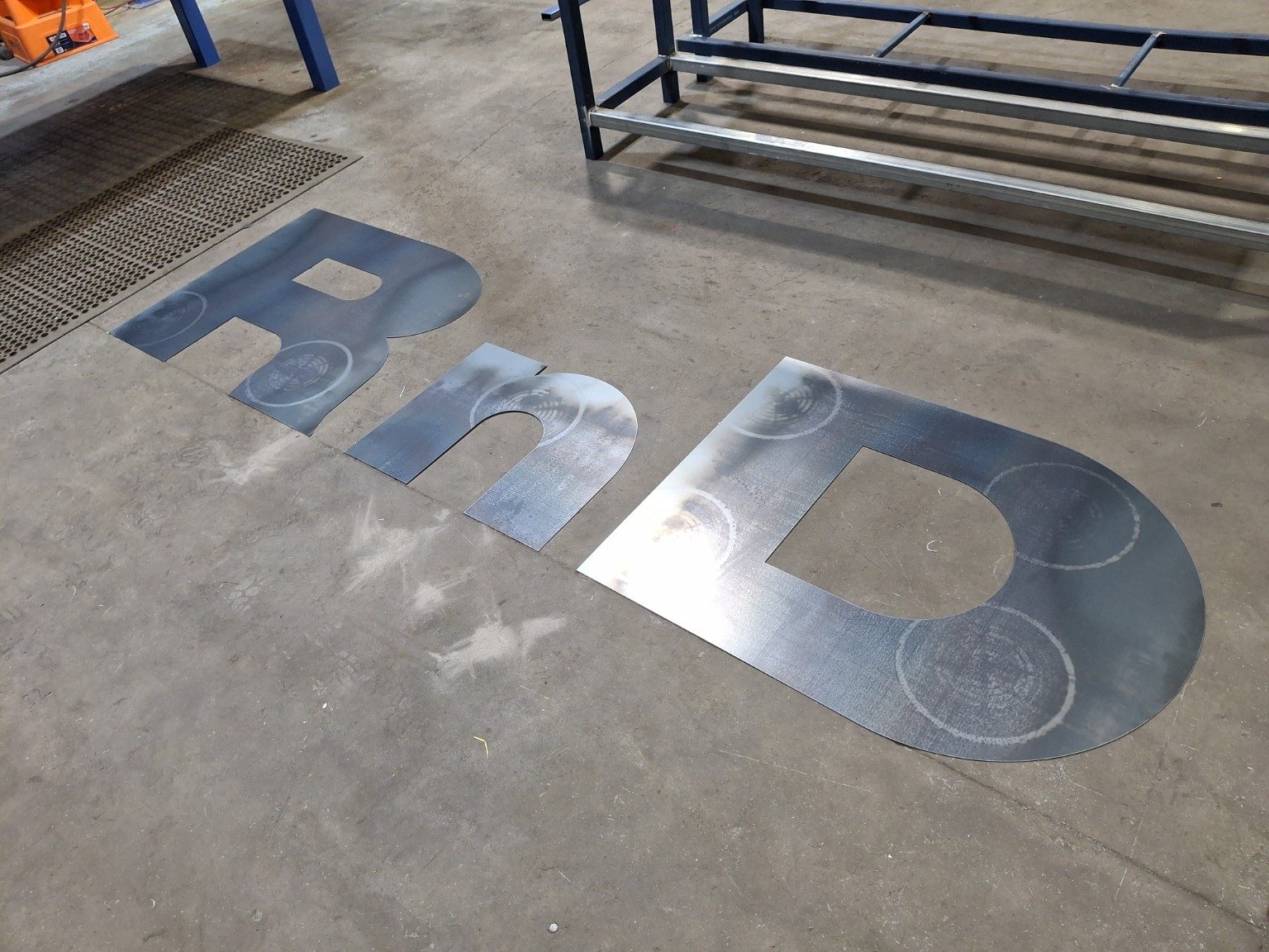 Laser cut RnD lettering on workshop floor